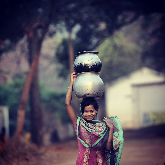 A tribal girl balances the water pots on her head after she fills them at a handpump in a village in Nabrangpur District, Orissa (Photo: Ravi Kanojia)