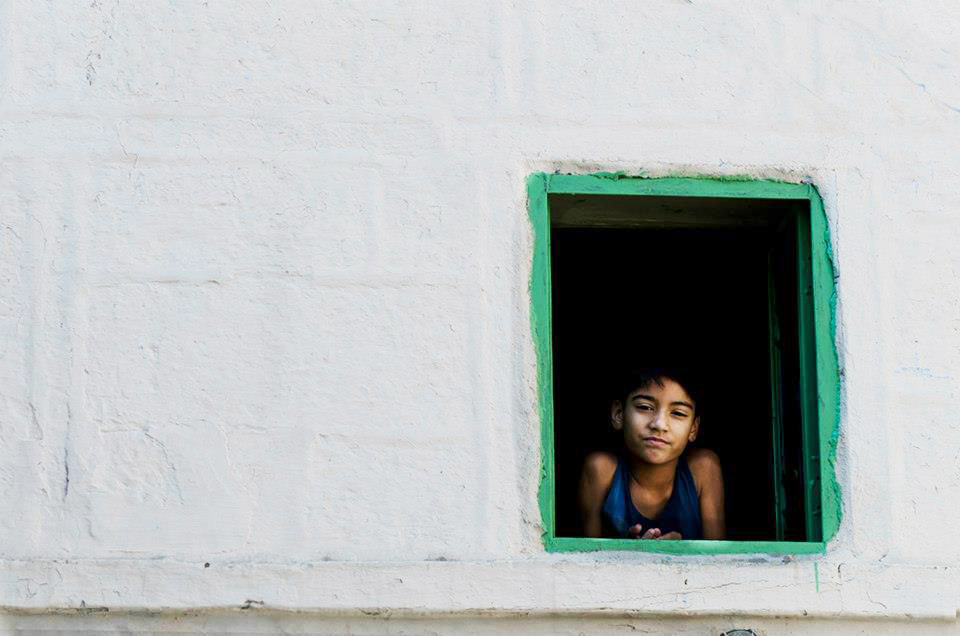 A kid looking through a window - Leher NGO in India