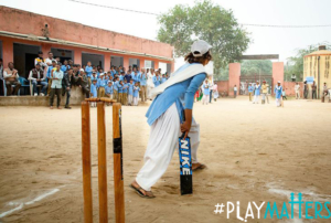 A girl playing cricket