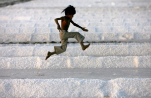 A child playing in a salt field and jumping