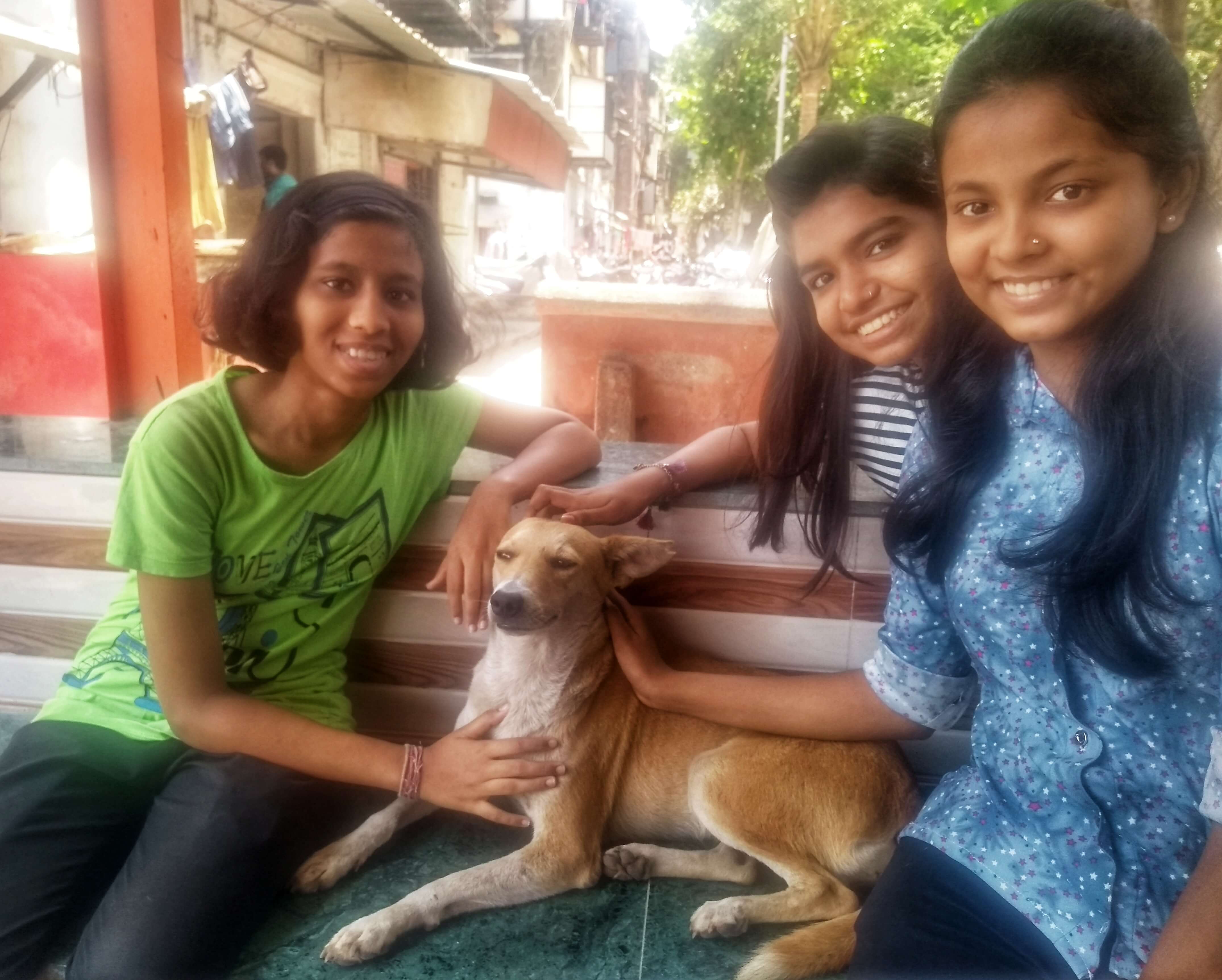 Shreya, Akanksha and Tanvi with their street pet dog at a community temple in Parel (Photo- City As Lab)