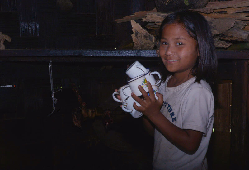 Young girl carrying cups