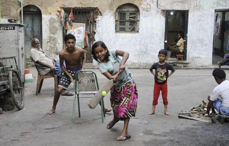 A girl child playing cricket